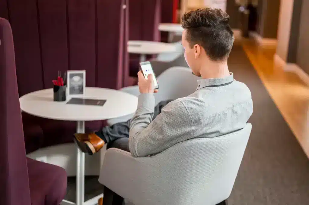 Open Space Gast checkt sein Smartphone im Girardet Haus Düsseldorf Königsallee 27